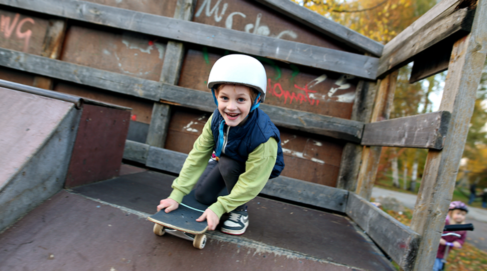Ein kleiner junge mit Skateboard auf einer Rampe