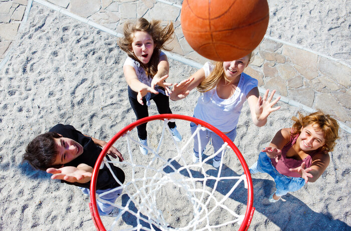 Vogelperspektive auf Kinder die einen Basketball in den Basketballkorb werfen