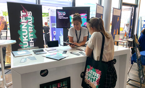 Eine Jugendliche am Infostand des Zukunuftspakets