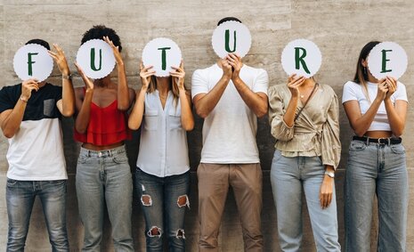 6 Jugendliche halten sich die Buchstaben FUTURE vors Gesicht
